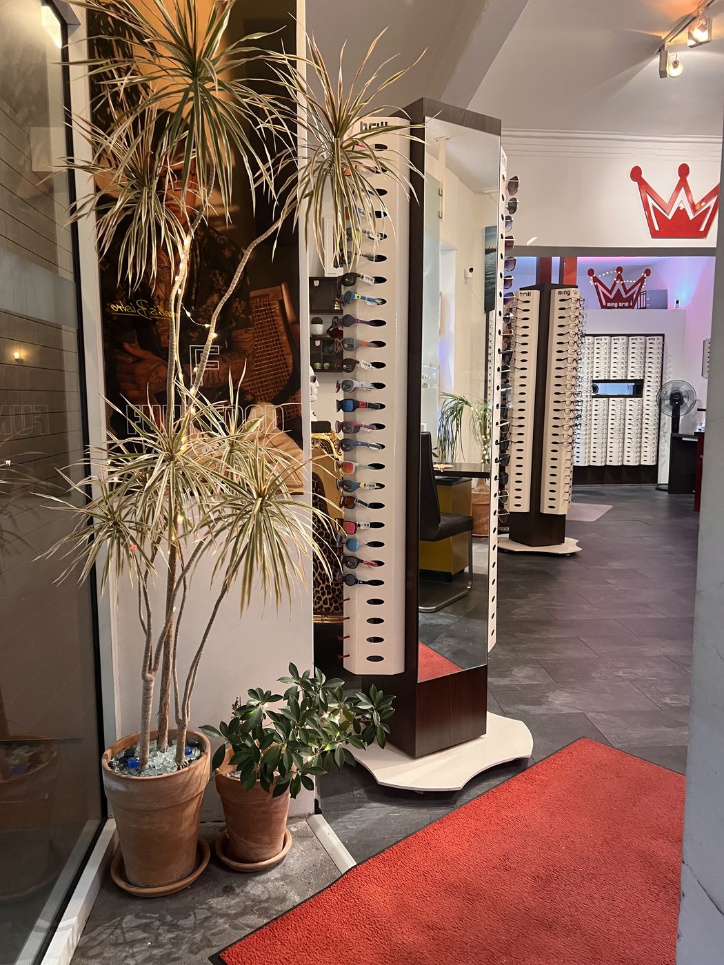 Der Eingang mit Palme, Spiegelsäule voller Sonnenbrillen und rotem Teppich