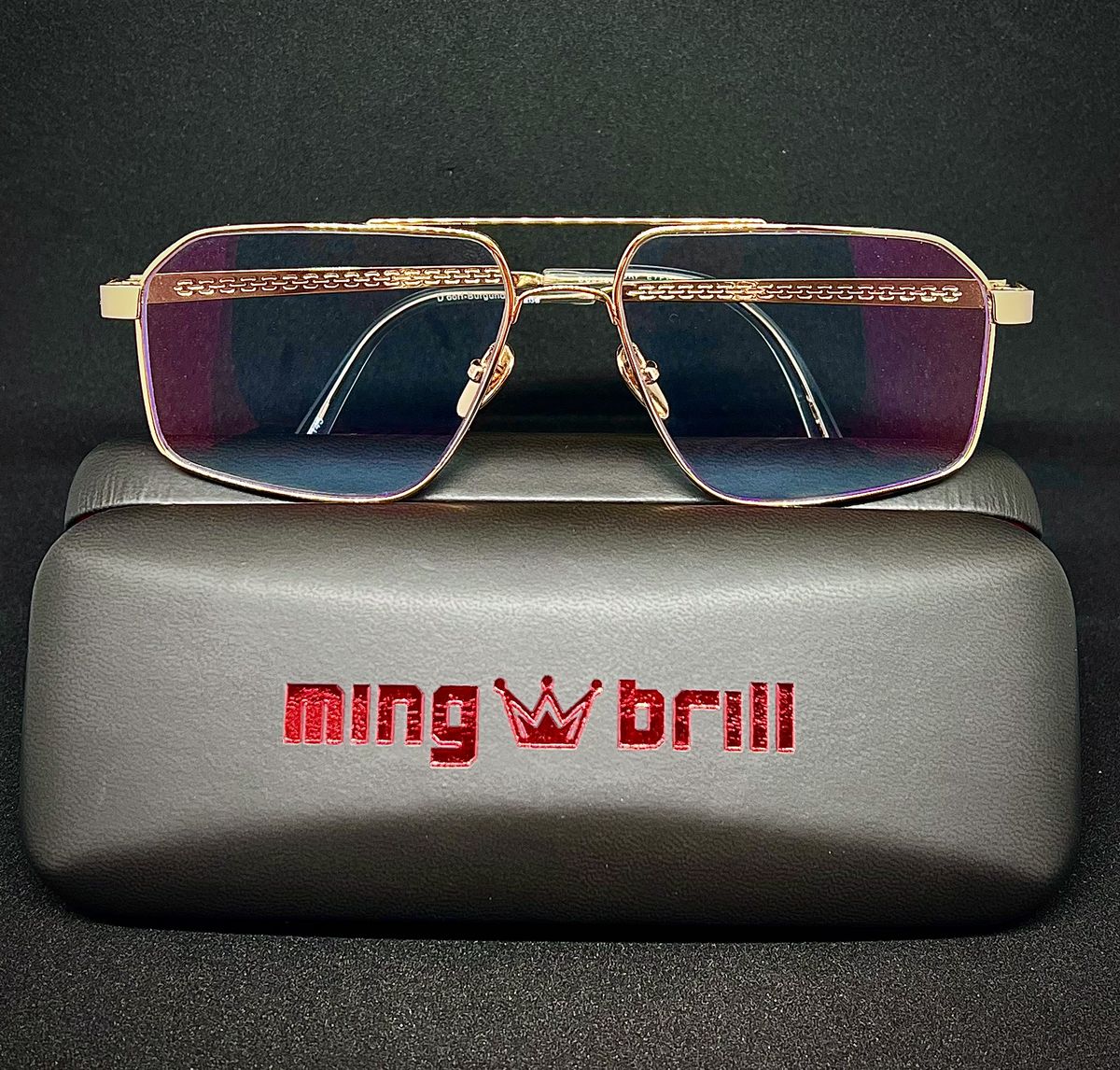 Goldene Fassung von Düsseldorf Eyewear auf einem Etui mit dem Ming-Brill-Schriftzug