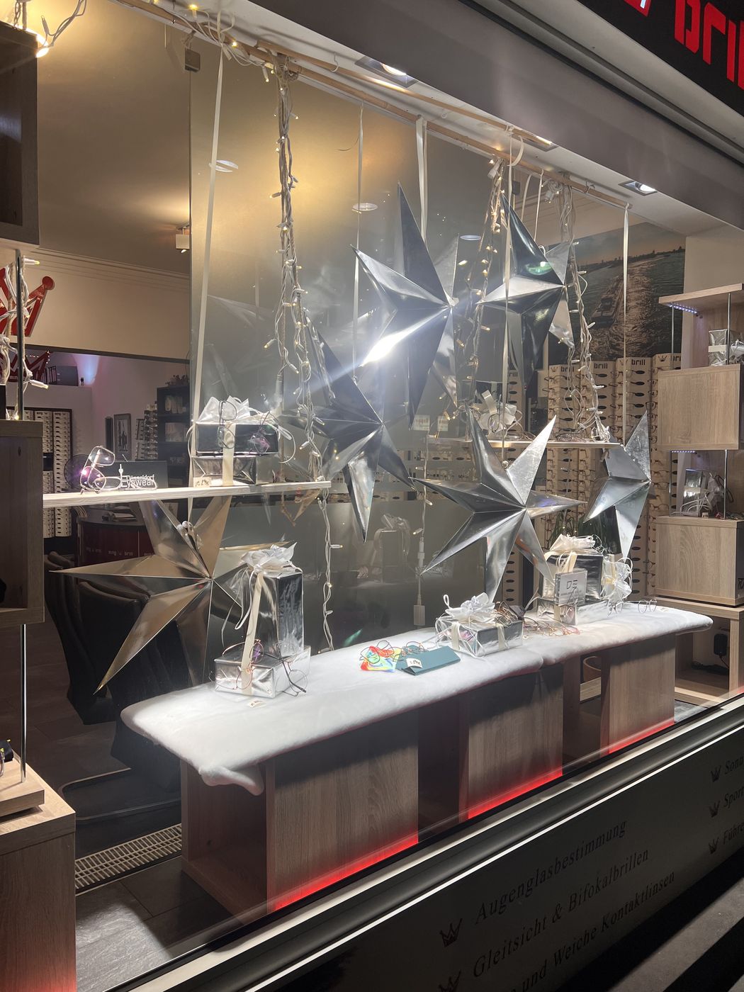 Das Schaufenster zur Weihnachtszeit mit silbernen Sternen und Geschenken